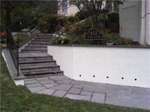 The finished project: new walkway, wall with drainage holes and new stucco